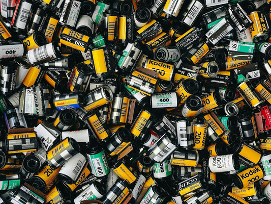 Comparison of Kodak 400 and Fujifilm 400 film rolls showing their colour, grain, and contrast differences for photographers.
